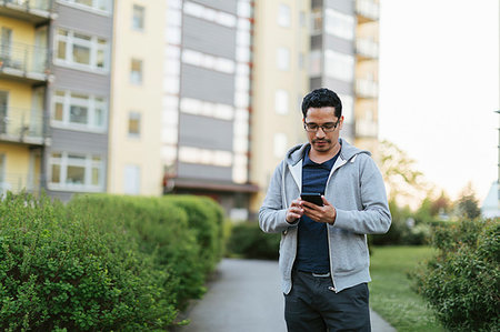 simsearch:6126-09267293,k - Man using smart phone by apartment building Stock Photo - Premium Royalty-Free, Code: 6126-09267259