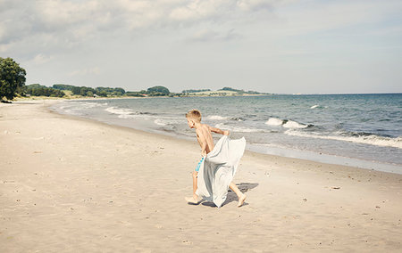 simsearch:6126-09267387,k - Boy carrying towel on beach Photographie de stock - Premium Libres de Droits, Code: 6126-09267392