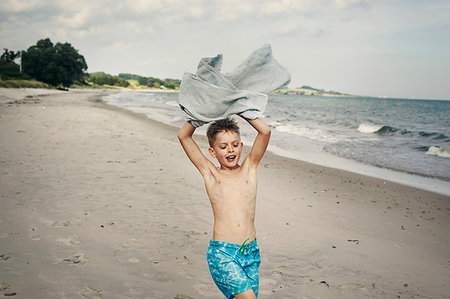 simsearch:6126-09267387,k - Boy carrying towel on beach Photographie de stock - Premium Libres de Droits, Code: 6126-09267394