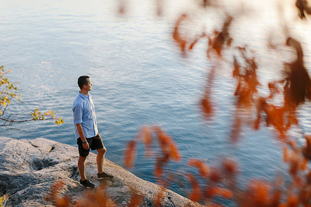 simsearch:6126-09266702,k - Man standing on rock by sea Fotografie stock - Premium Royalty-Free, Codice: 6126-09267302