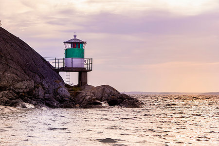 simsearch:6126-09266702,k - Lighthouse on rocks by sea during sunset in Kanholm Bay, Sweden Fotografie stock - Premium Royalty-Free, Codice: 6126-09267425