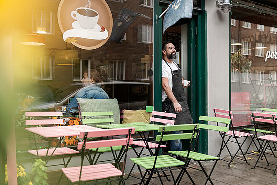 Small business owner outside his cafe Stock Photo - Premium Royalty-Free, Image code: 6126-09267625