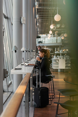 Woman using laptop in airport Stock Photo - Premium Royalty-Free, Code: 6126-09267734