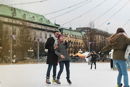 Couple taking selfie while ice skating Foto de stock - Sin royalties Premium, Código: 6126-09267831