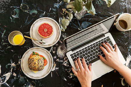 simsearch:649-08702456,k - Hands of woman using laptop during breakfast Photographie de stock - Premium Libres de Droits, Code: 6126-09267955