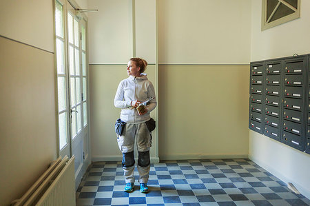 patterned tiled floor - Painter by mailboxes in apartment building Foto de stock - Sin royalties Premium, Código: 6126-09268108