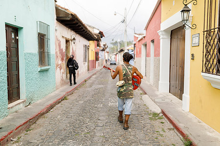 simsearch:6126-09204311,k - Man walking down street with guitar in Guatemala Photographie de stock - Premium Libres de Droits, Code: 6126-09204302