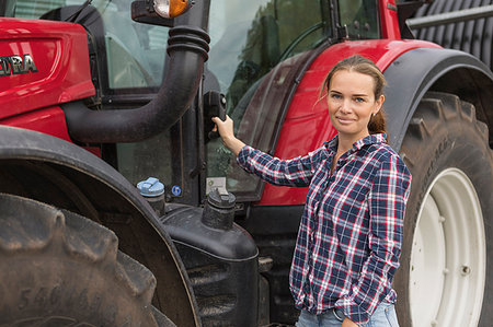 Agricultural worker standing next to a tractor in field Stock Photo - Premium Royalty-Free, Code: 6126-09204572