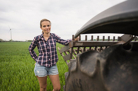 Agricultural worker standing next to a tractor in field Stock Photo - Premium Royalty-Free, Code: 6126-09204577