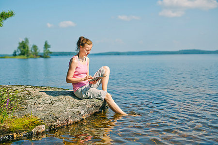relaxing tablet lake - Mid adult woman looking at a tablet in front of a lake in Finland Stock Photo - Premium Royalty-Free, Code: 6126-09204682