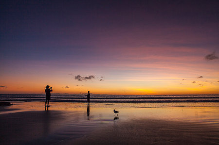 Person taking a photo of someone fishing on the beach at sunset in Broome, Australia Stock Photo - Premium Royalty-Free, Code: 6126-09204635