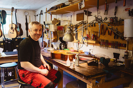 Craftsman smiling in guitar making workshop Stock Photo - Premium Royalty-Free, Code: 6126-09204873