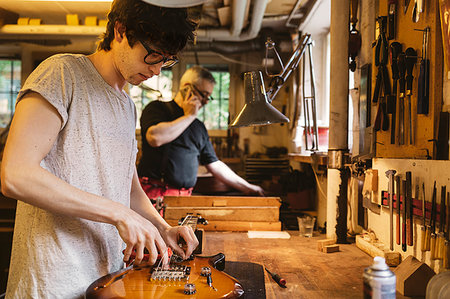 Craftsman working in guitar making workshop Stock Photo - Premium Royalty-Free, Code: 6126-09204879