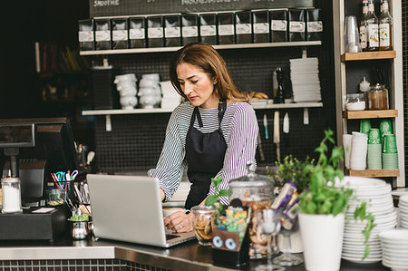 simsearch:6126-09204829,k - Barista using laptop at cafe counter Stock Photo - Premium Royalty-Free, Code: 6126-09204823