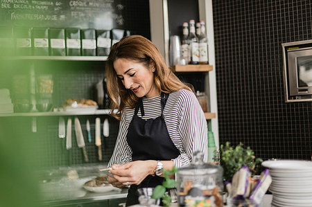 simsearch:6126-09204829,k - Barista holding smart phone at cafe counter Stock Photo - Premium Royalty-Free, Code: 6126-09204821