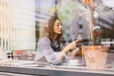 small business phone outside - Barista using smart phone behind cafe window Stock Photo - Premium Royalty-Free, Code: 6126-09204827