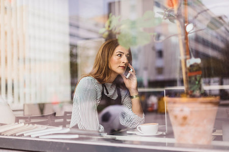 small business phone outside - Barista using smart phone behind cafe window Stock Photo - Premium Royalty-Free, Code: 6126-09204826