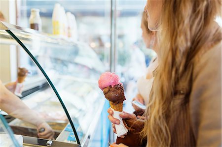 Midsection of woman holding ice cream cone at parlor Foto de stock - Sin royalties Premium, Código: 6127-08666369