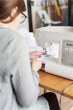 Rear view of design professional using sewing machine Photographie de stock - Premium Libres de Droits, Code: 6127-08666631