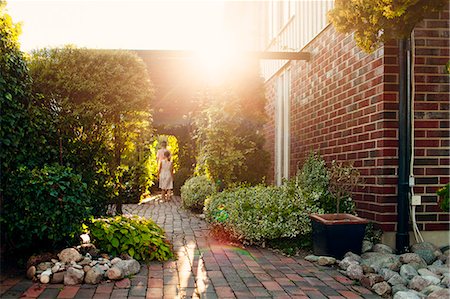 Rear view of brother and sister walking in backyard Photographie de stock - Premium Libres de Droits, Code: 6127-08667240
