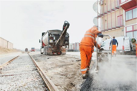 spreading - Rear view of manual worker laying asphalt at construction site Stock Photo - Premium Royalty-Free, Code: 6127-08667530