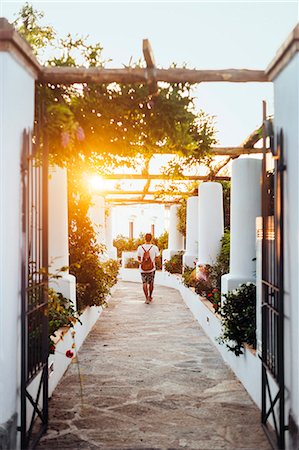 Full length rear view of man walking on footpath Photographie de stock - Premium Libres de Droits, Code: 6127-08687952