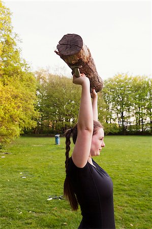 Woman holding log and exercising at park Foto de stock - Sin royalties Premium, Código: 6127-08688376