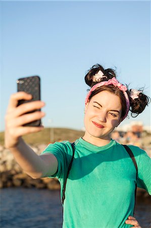 Young woman taking selfie through mobile phone at shore Stock Photo - Premium Royalty-Free, Code: 6127-08689261