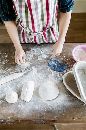 flour - High angle view of hand dusting flour on dough in bakery Stock Photo - Premium Royalty-Free, Code: 6127-08689299