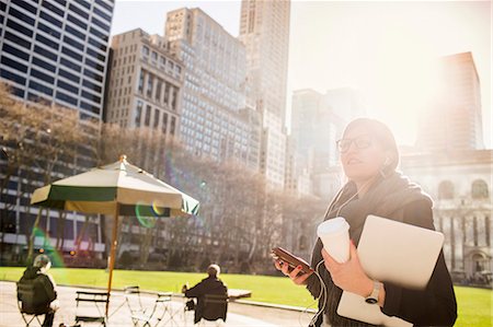 Businesswoman listening music while waiting at Bryant Park against buildings Stock Photo - Premium Royalty-Free, Code: 6127-08704270