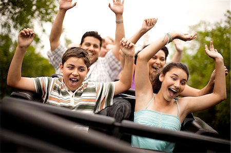Smiling family riding on a rollercoaster at an amusement park. Stock Photo - Premium Royalty-Free, Code: 6128-08747441
