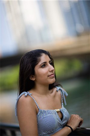 Young woman standing near an inner city river. Stock Photo - Premium Royalty-Free, Code: 6128-08747466