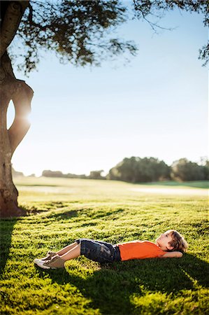 Young boy peacefully lying in a field. Foto de stock - Sin royalties Premium, Código: 6128-08747485