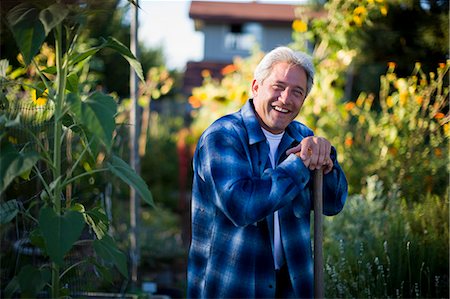 simsearch:649-07437978,k - Portrait of a happy mature man leaning on the handle of a spade in his garden Stock Photo - Premium Royalty-Free, Code: 6128-08747542