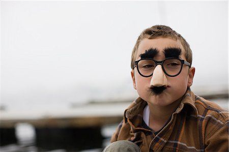 simsearch:6128-08798764,k - Portrait of a boy wearing funny glasses with a nose and mustache. Stock Photo - Premium Royalty-Free, Code: 6128-08747560