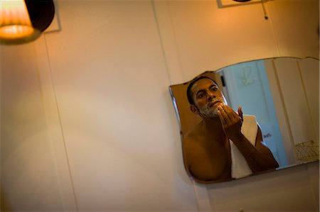 simsearch:6122-07698043,k - Young man preparing to shave his face in the bathroom mirror. Stock Photo - Premium Royalty-Free, Code: 6128-08747587