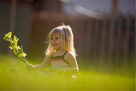 shoulders mom - Little girl sitting on lawn holding yellow flowers Photographie de stock - Premium Libres de Droits, Code: 6128-08747591