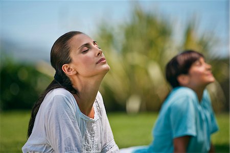 simsearch:6102-08747066,k - Serene mid adult women practicing yoga in a serene green park. Stockbilder - Premium RF Lizenzfrei, Bildnummer: 6128-08747502