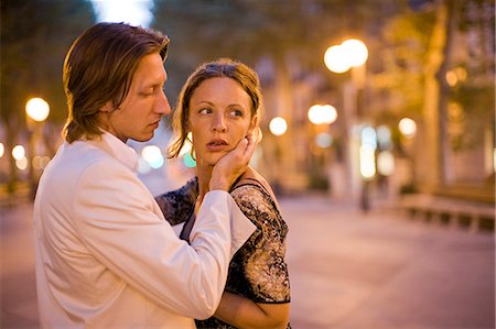 Young adult couple kissing on a lit street at sunset. Stock Photo - Premium Royalty-Free, Code: 6128-08747508