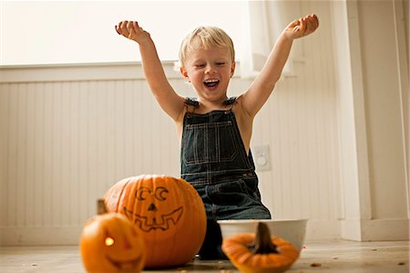 simsearch:6128-08728277,k - Exited little boy holding up innards scooped from Halloween pumpkins Photographie de stock - Premium Libres de Droits, Code: 6128-08747648