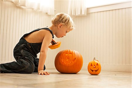 simsearch:6128-08738117,k - Little boy looking inside Halloween pumpkin Foto de stock - Sin royalties Premium, Código: 6128-08747649