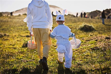 Two brothers in Easter costumes on an Easter egg hunt Stock Photo - Premium Royalty-Free, Code: 6128-08747655