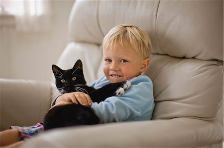 A young boy cuddles his cat. Stock Photo - Premium Royalty-Free, Code: 6128-08747695