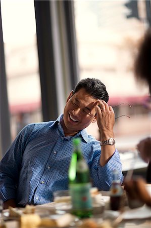 Cheerful businessman enjoys a lunch meeting at a restaurant. Stock Photo - Premium Royalty-Free, Code: 6128-08747613