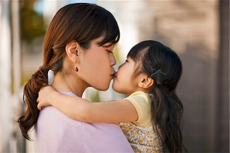 simsearch:6128-08728378,k - Mother and daughter sharing a kiss. Foto de stock - Sin royalties Premium, Código: 6128-08747734