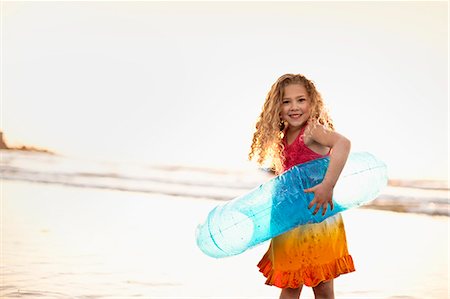 simsearch:6128-08747842,k - Young girl playing with an inflatable ring at the beach. Stockbilder - Premium RF Lizenzfrei, Bildnummer: 6128-08747864