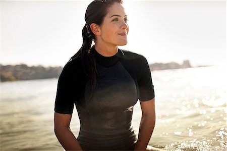 pretty - Young female surfer sitting on surfboard,  waiting for a wave. Stock Photo - Premium Royalty-Free, Code: 6128-08747875