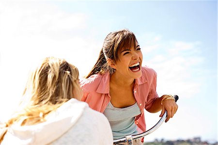 simsearch:6128-08738600,k - Girl on a bicycle,  laughing with her friend. Stock Photo - Premium Royalty-Free, Code: 6128-08747878