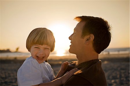 Father holding smiling son at the beach Photographie de stock - Premium Libres de Droits, Code: 6128-08747881