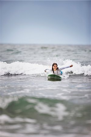 smiling brunette woman - Young woman surfing at the beach. Stock Photo - Premium Royalty-Free, Code: 6128-08747817
